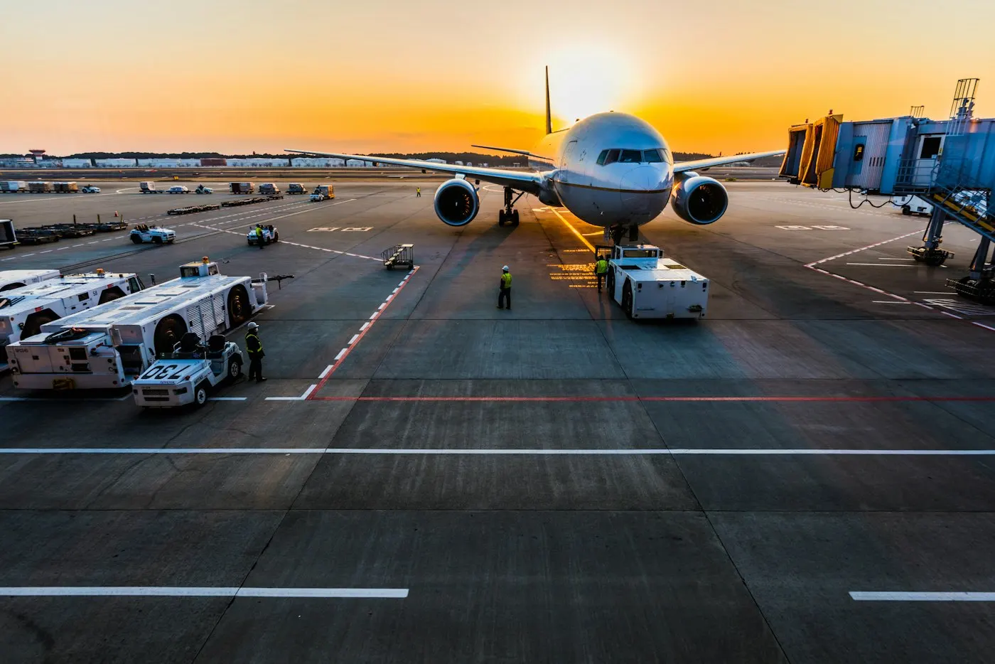 Passenger aircraft at an airport gate at sunrise