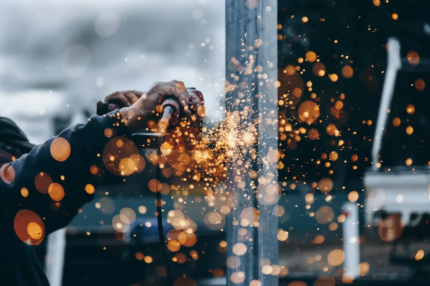 Worker welding metal with sparks in a workshop
